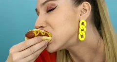 hungry-woman-eating-hot-dog-footage-160454182_iconm.jpeg