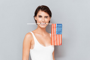 graphicstock-happy-young-woman-holding-usa-flag-in-teeth-and-winking-over-gray-background_S_M4Ba4rne_thumb.jpg